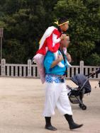境内での太鼓の奉納が終わると、打ち子は若い衆に肩車されて、参詣する。